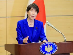 記者会見で発言する高市早苗首相。背後に日本国旗。